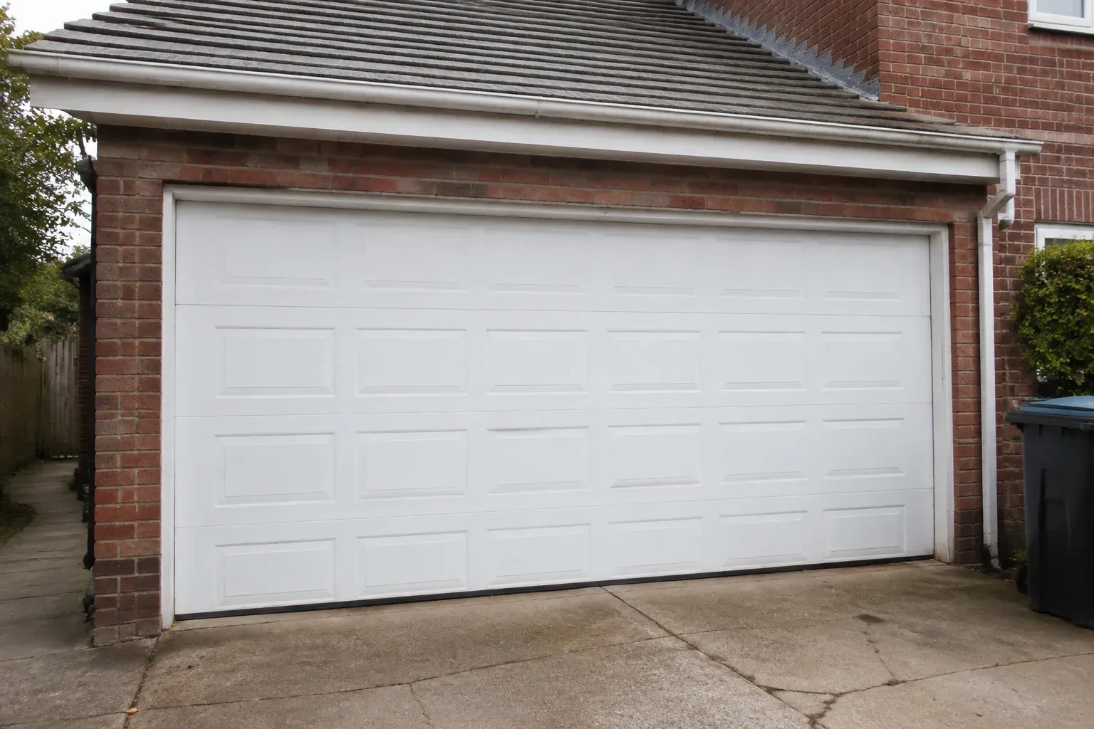 Closed white sectional garage door at an ordinary brick house. — Sectional Garage Door Replacement, Orangeville